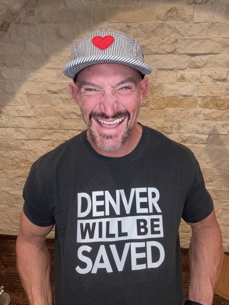 Steve Weatherford smiling and wearing the official Denver Will Be Saved black t-shirt